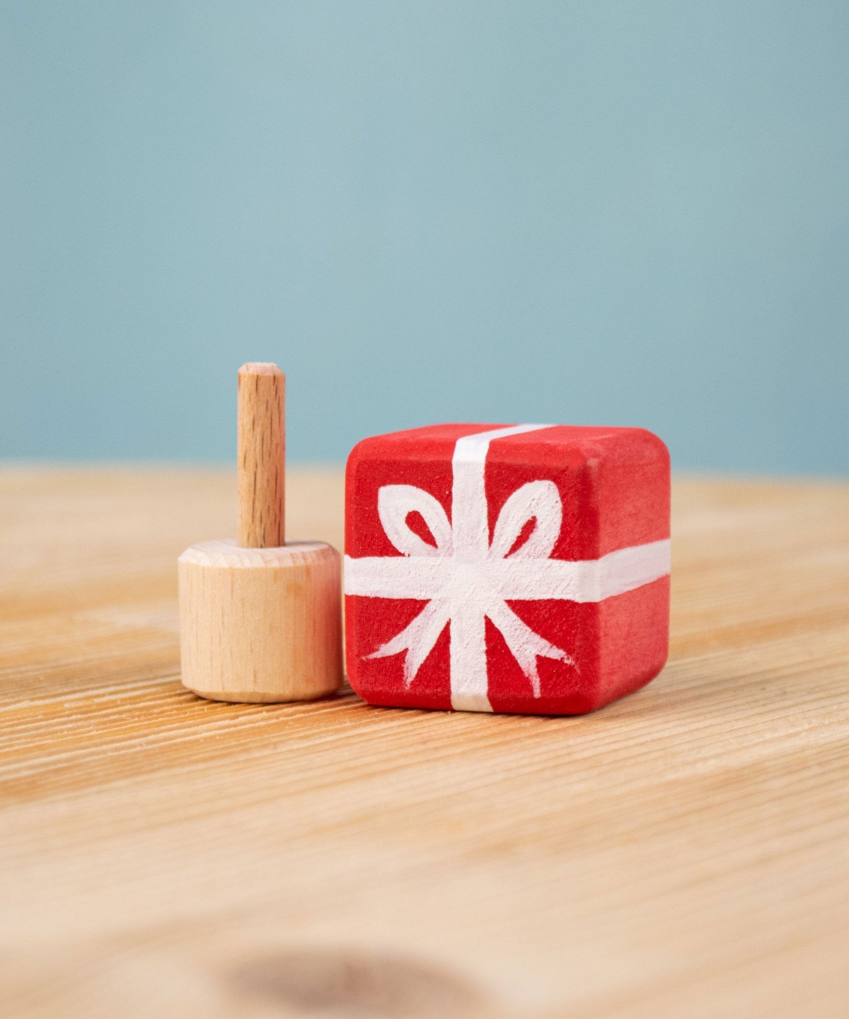 Bumbu red Festive Gift Celebration decorative Figure to fit on a Grimm's celebration ring. The figure is shown with the gift sepearated from the base These festive figures are perfect for your Chritmas celebration ring set up. Bumbu red Festive Gift Celebration decorative Figure to fit on a Grimm's celebration ring. These festive figures are perfect for your Christmas celebration ring set up. These expertly hand crafted items are part of a large range of wooden toys available here at Babipur. 