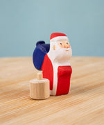 Bumbu red Festive Santa Celebration decorative Figure to fit on a Grimm's celebration ring. The Father Christmas figure is shown off it's wooden base. These festive figures are perfect for your Christmas celebration ring set up. These expertly hand crafted items are part of a large range of wooden toys available here at Babipur. 