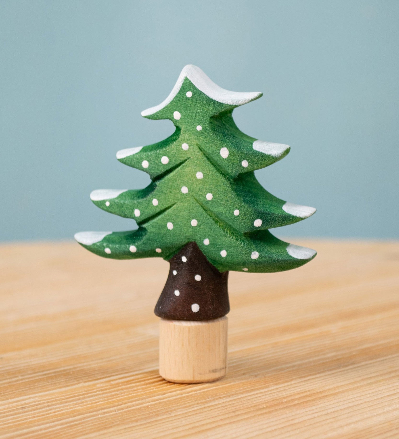 Bumbu Festive Tree Celebration decorative Figure to fit on a Grimm's celebration ring. The figure is a green fir tree decorated with snow. These festive figures are perfect for your Christmas celebration ring set up. These expertly hand crafted items are part of a large range of wooden toys available here at Babipur. 