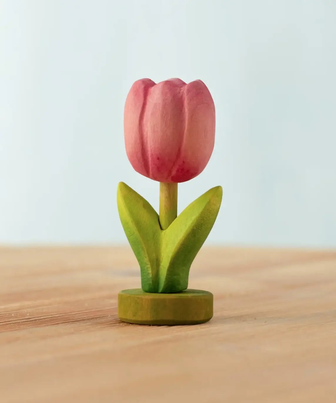 Bumbu handcrafted wooden pink festive tulip figure standing on wooden green base