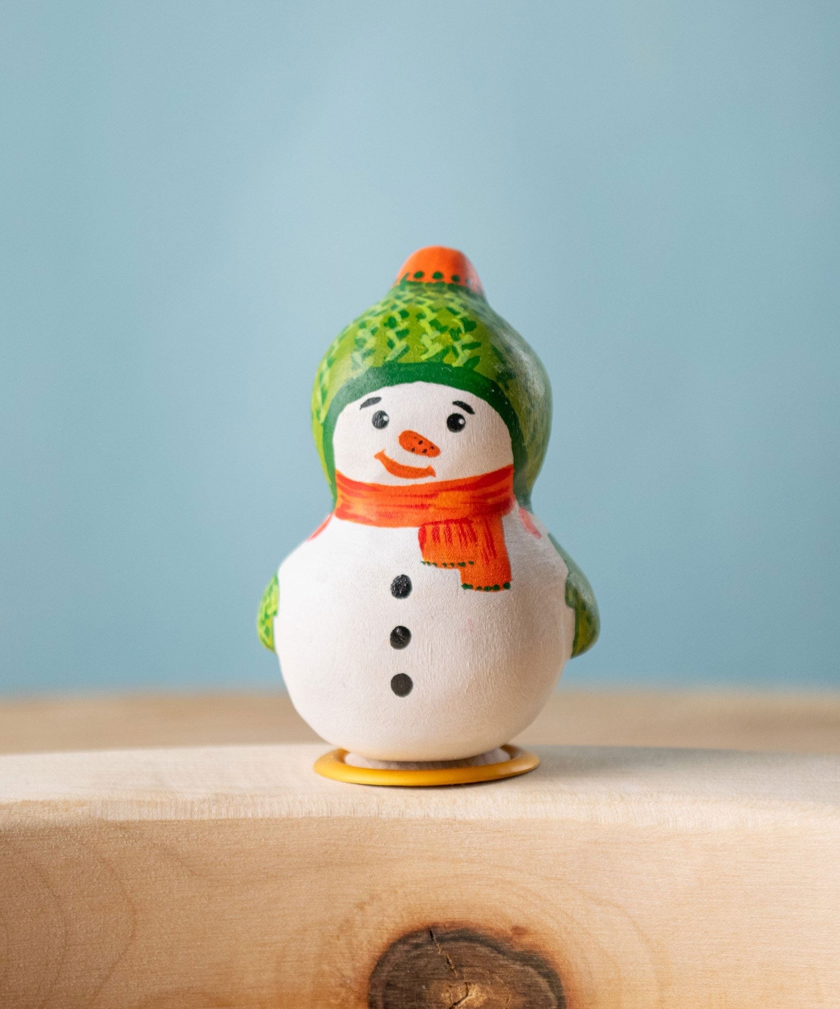 Bumbu Festive Snowman Celebration decorative Figure to fit on a Grimm's celebration ring. The handpainted snowman figure has a green hat with matching gloves and an orange scarf. These festive figures are perfect for your Christmas celebration ring set up. These expertly hand crafted items are part of a large range of wooden toys available here at Babipur.  