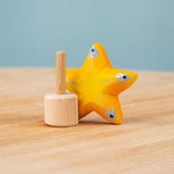 Bumbu yellow Festive Star Celebration decorative Figure to fit on a Grimm's celebration ring. The wooden yellow star is shown separated from the wooden base that comes with it.  These festive figures are perfect for your Christmas celebration ring set up. These expertly hand crafted items are part of a large range of wooden toys available here at Babipur. 