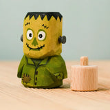 Bumbu handcrafted wooden Frankenstein halloween decorative figure next to a wooden display peg