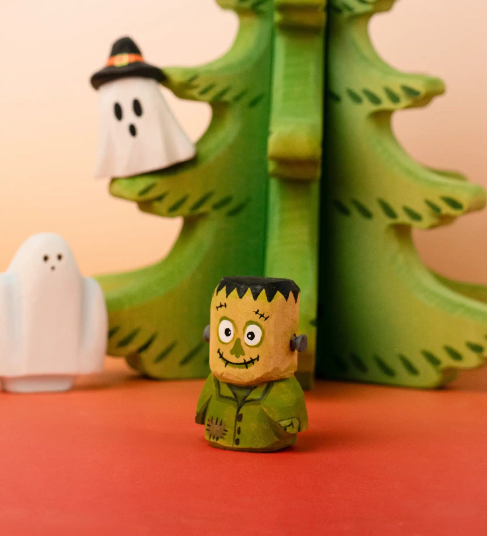 Bumbu handcrafted wooden Frankenstein halloween decorative figure in front of a tree and spooky ghost figures
