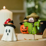 Bumbu ghost wizard and scarecrow decorative figures placed on a natural wooden celebration ring. 