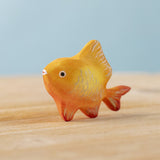 The Bumbu hand carved wooden toy goldfish figure from Bumbu, painted in orange with sparkly golden scales.
