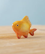 The Bumbu hand carved wooden toy goldfish figure from Bumbu, painted in orange with sparkly golden scales.