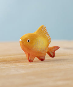 The Bumbu hand carved wooden toy goldfish figure from Bumbu, painted in orange with sparkly golden scales.