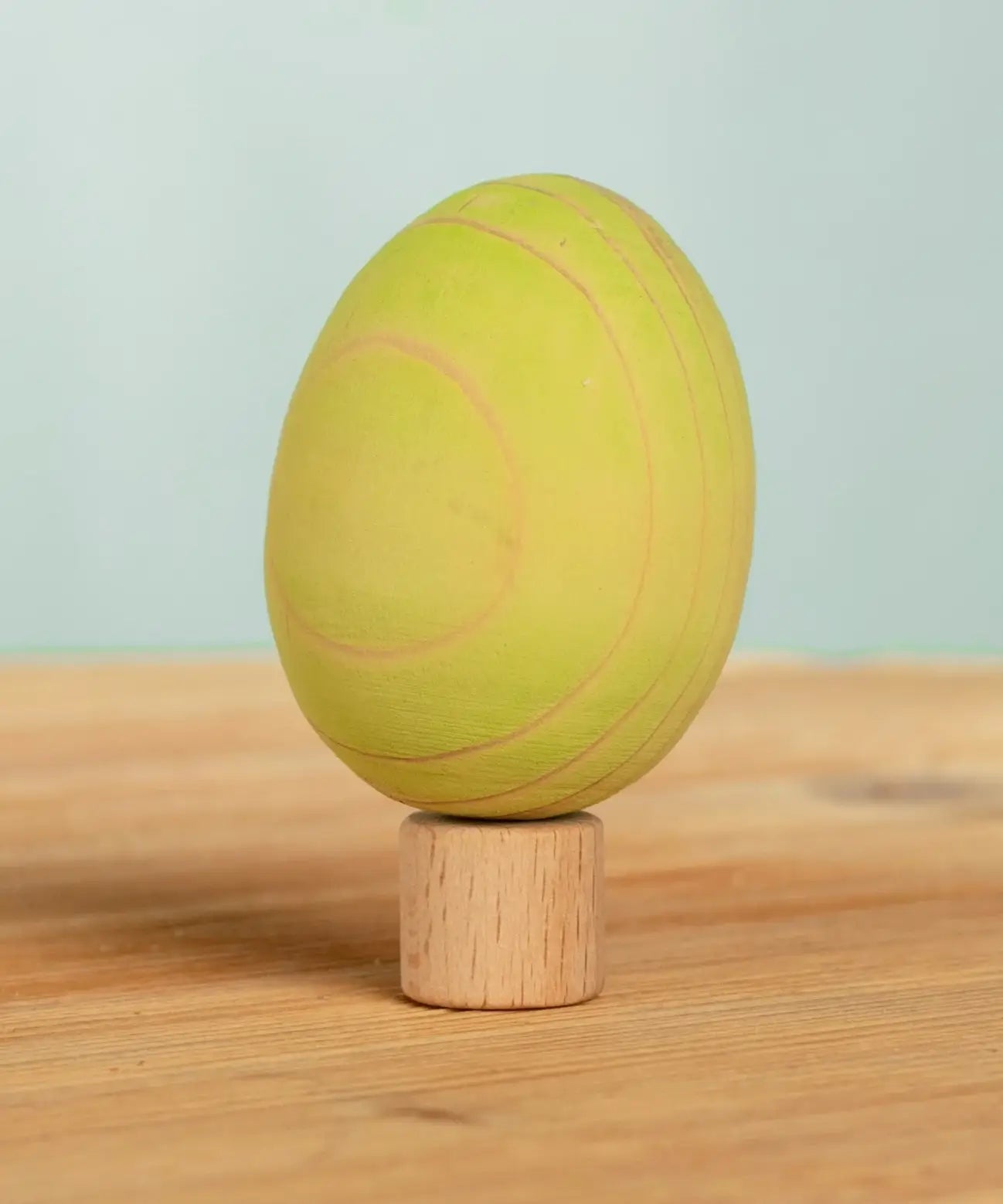 Bumbu handcrafted wooden green egg figure standing on wooden base for Grimms celebration ring