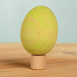 Bumbu handcrafted wooden green egg figure standing on wooden base for Grimms celebration ring