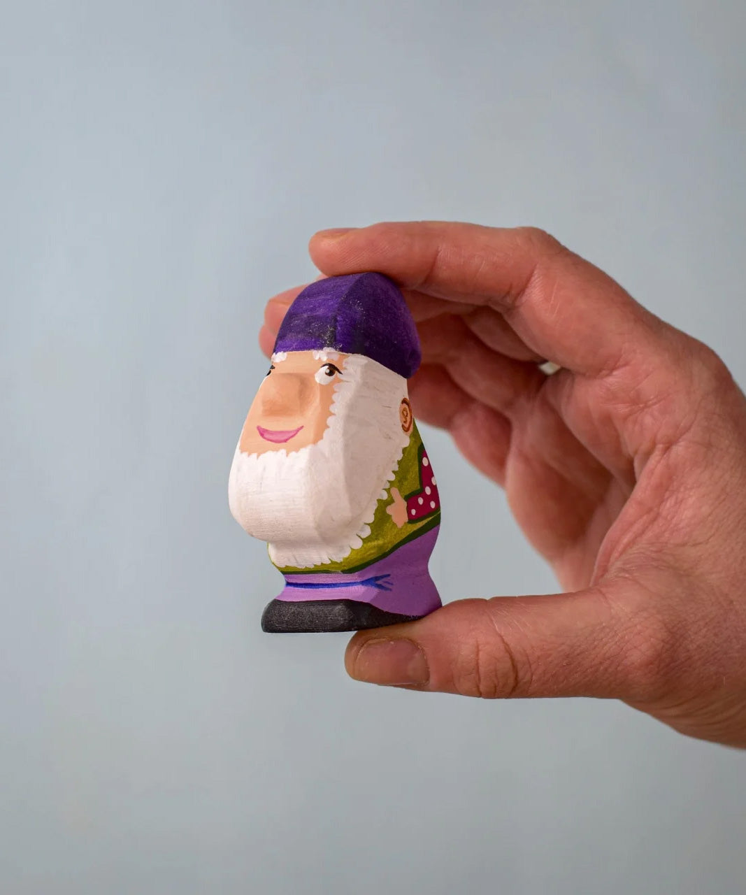 A Bumbu Toys Grumble Dwarf in an adult's hand.