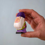 A Bumbu Toys Grumble Dwarf in an adult's hand.
