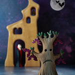 a hand carved wooden toy in the shape of a spooky Halloween tree