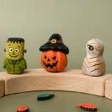 Bumbu handcrafted wooden Frankenstein halloween figure standing on a celebration ring piece next to a pumpkin and mummy decorative figure