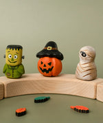Bumbu handcrafted wooden Frankenstein halloween figure standing on a celebration ring piece next to a pumpkin and mummy decorative figure