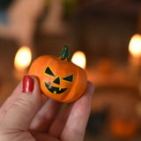 A medium Bumbu wooden pumpkin figure shown in an adult's hand for scale. These wooden figures are part of a wide range of expertly hand crafted wooden toys here at Babipur. 