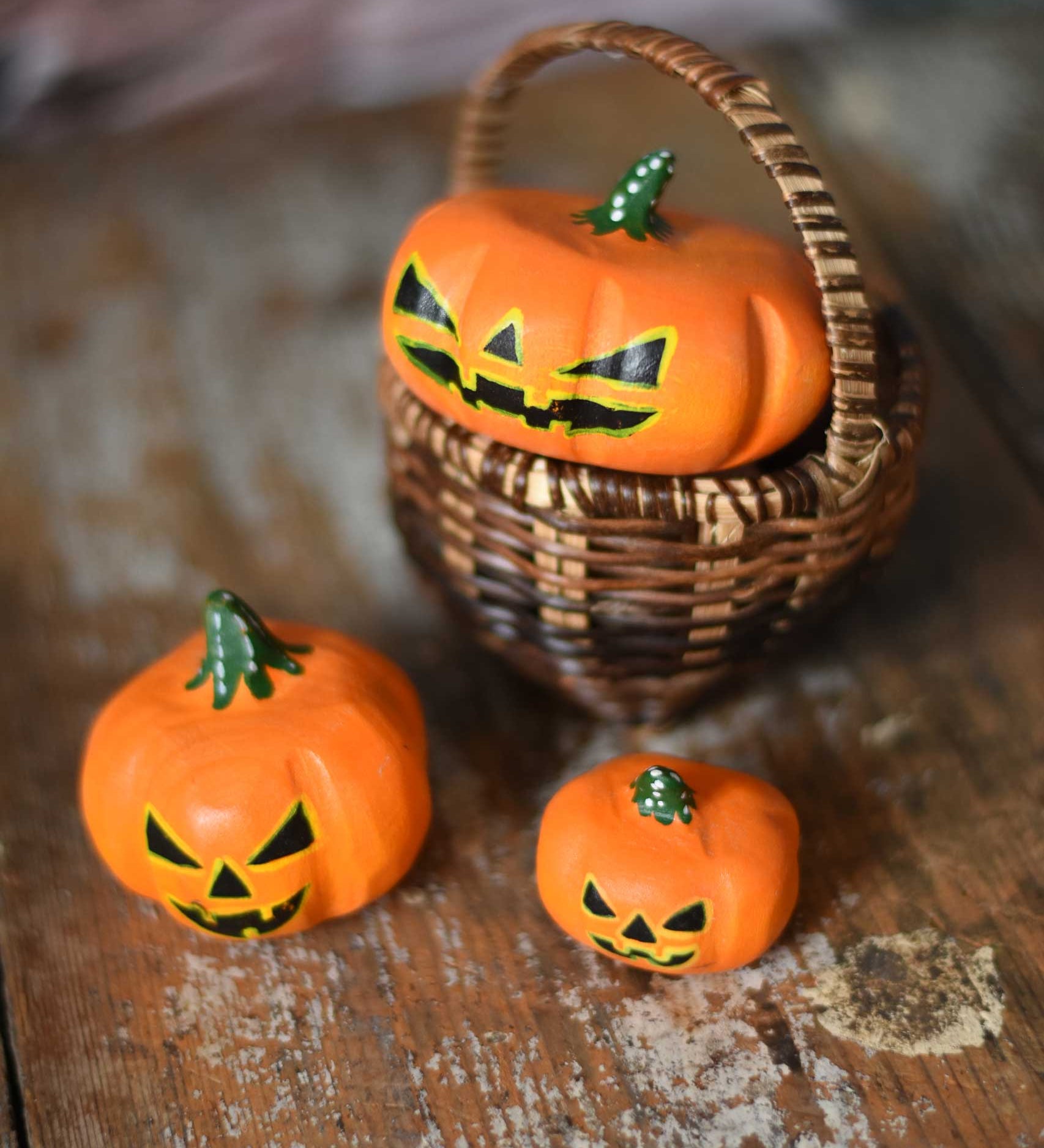 Bumbu Halloween pumpkins placed in and around a Kraul basket on a wooden surface. These wooden figures are part of a wide range of expertly hand crafted wooden toys here at Babipur. 