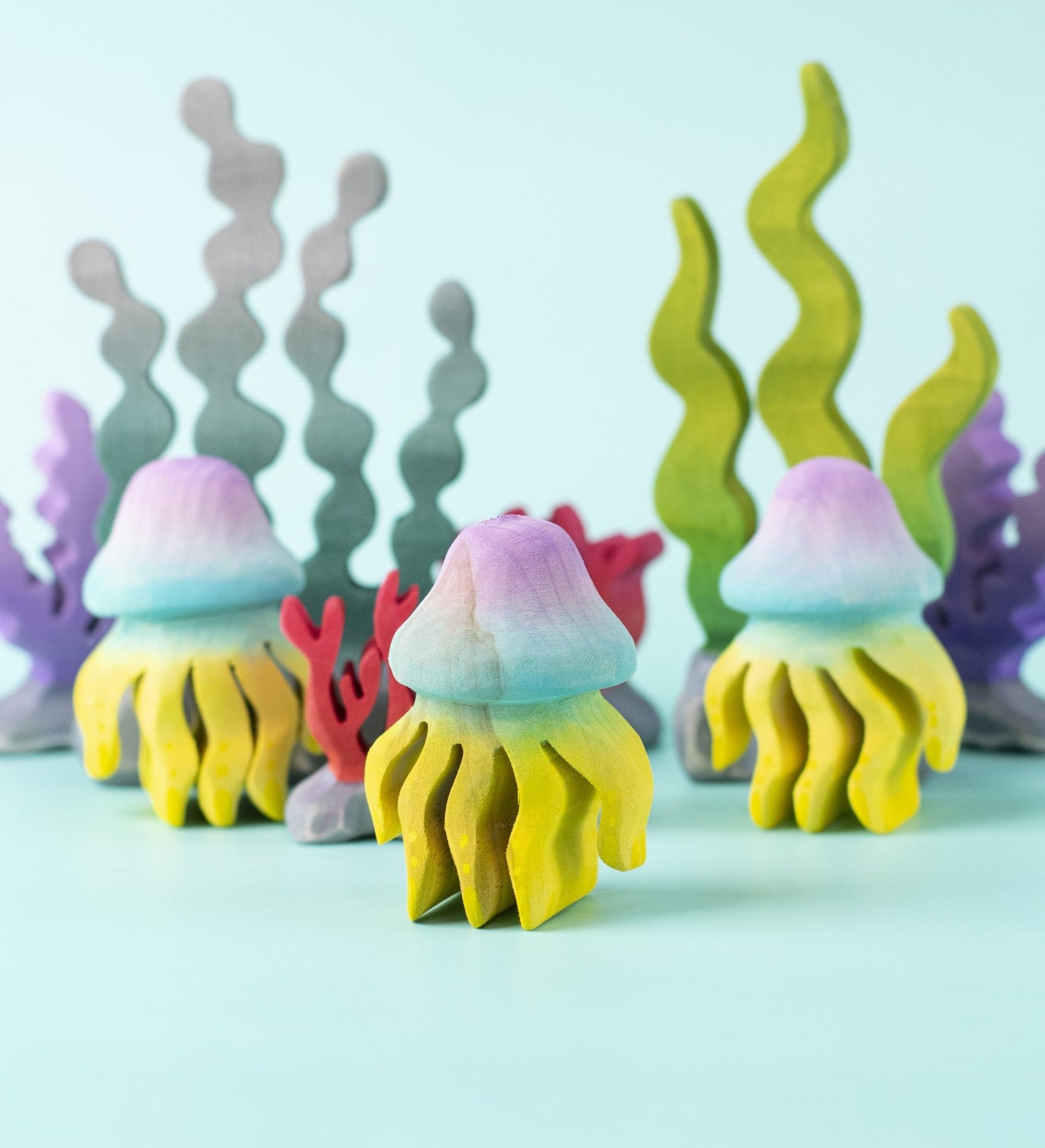 The Bumbu handmade wooden jellyfish toy figures, with Bumbu wooden seaweed and kelp toys in the background. 