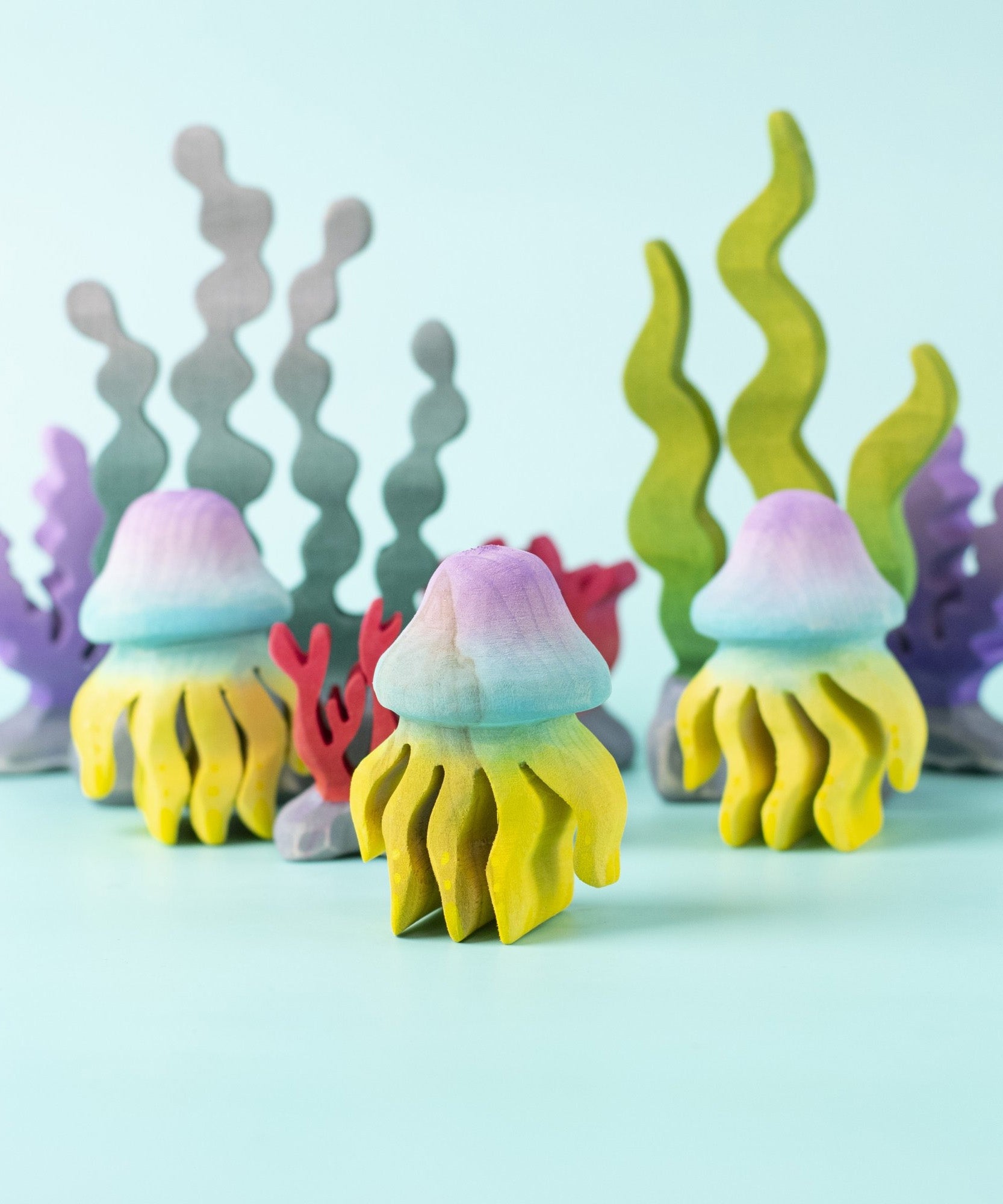 The Bumbu handmade wooden jellyfish toy figures, with Bumbu wooden seaweed and kelp toys in the background. 