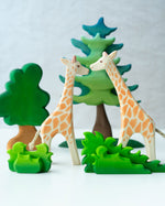 2 Ostheimer giraffe figures stood on a white background behind the Bumbu small and large wooden shrub toys