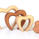 Pieces of the Bumbu eco-friendly wooden stacking heart lined up on a white background