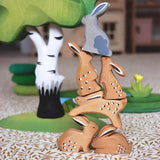 Bumbu Wooden Grey Sitting Rabbit. The grey rabbit sits aloft brown rabbits to form a pyramid.