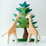 2 Ostheimer giraffe figures stood on a white background next to a Bumbu plastic-free spruce tree toy