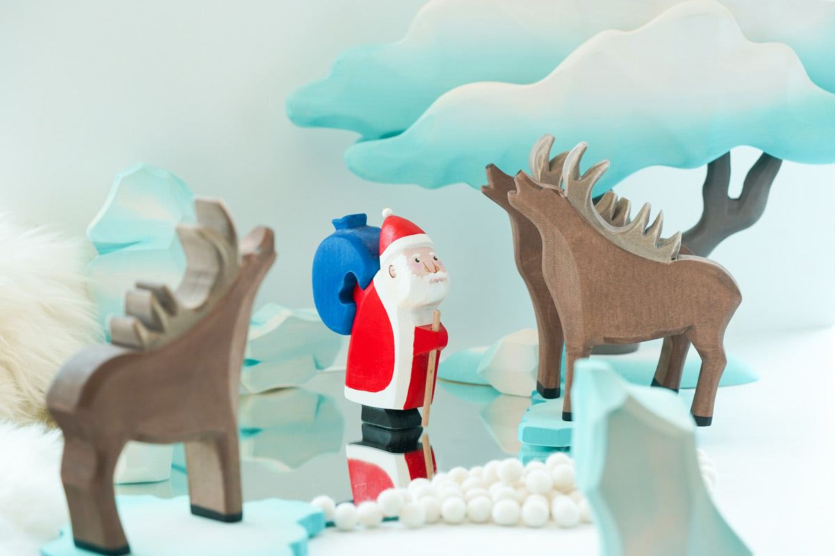 Bumbu handmade wooden stag figures stood on some Bumbu ice floes next to a small Father Christmas figure