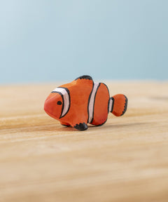 The Bumbu hand carved wooden Clownfish toy. It is hand painted in orange with black and white stripes.
