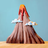 Bumbu Wooden Volcano Set. The toy sits on a wooden surface against a blue background.