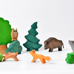 Bumbu large tree and other handmade wooden Bumbu toys scattered on a white background to make an animal nature scene