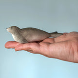 Bumbu harp seal handmade wooden toy figure in an adult's hand