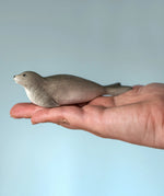 Bumbu harp seal handmade wooden toy figure in an adult's hand