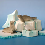 Bumbu Toys harp seal family handmade wooden toy figure placed on a wooden ice berg scenery piece in a small world play scene.