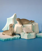 Bumbu Toys harp seal family handmade wooden toy figure placed on a wooden ice berg scenery piece in a small world play scene.
