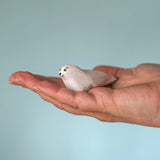 Bumbu Toys harp seal pup handmade wooden toy figure in an adult's hand.