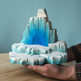 Adult hand holding the Bumbu wooden iceberg showing scale