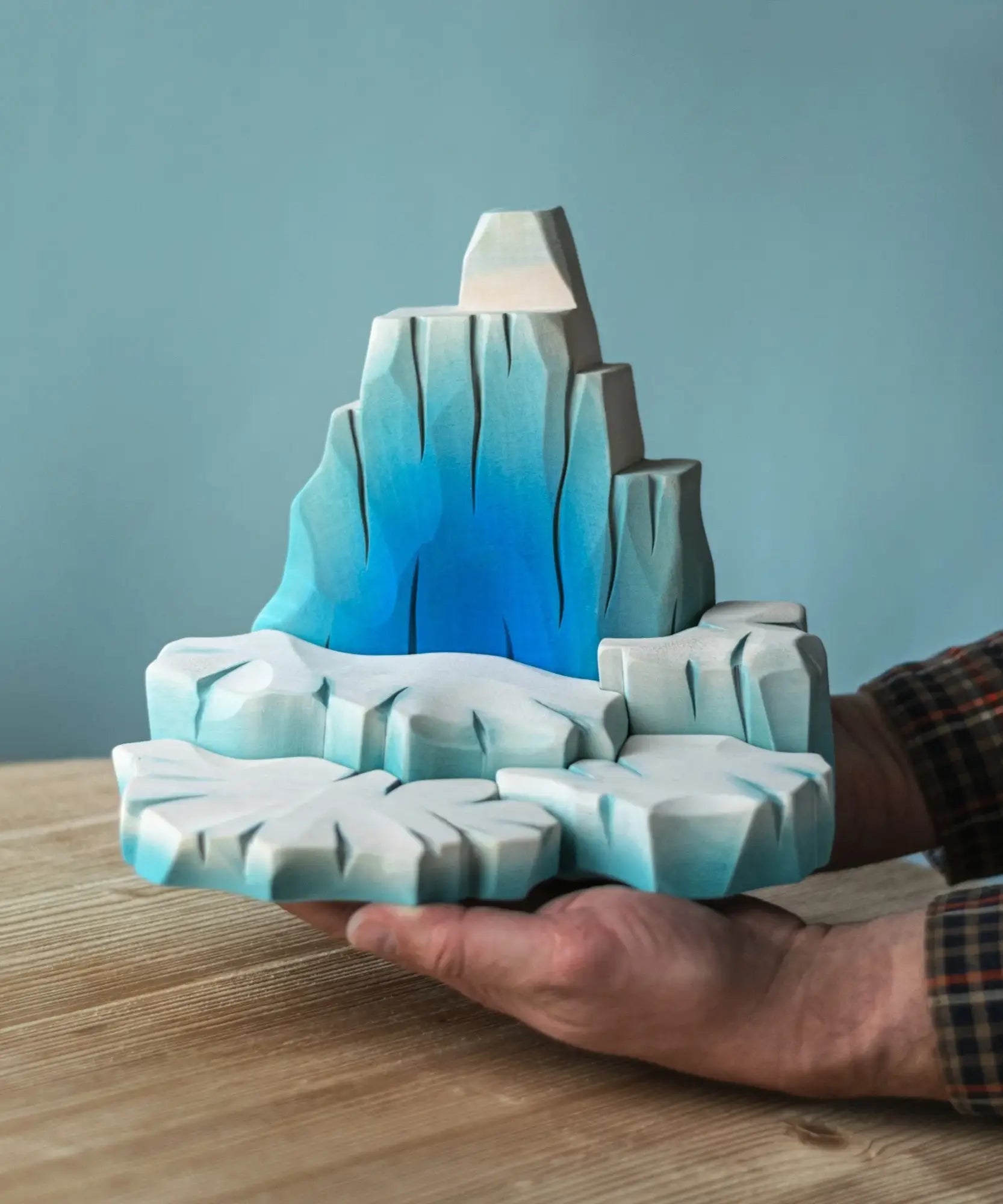Adult hand holding the Bumbu wooden iceberg showing scale