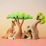 Bumbu Toys Mama Kangaroo & Joey figures set up in a small world lay scene along with other Bumbu toys.