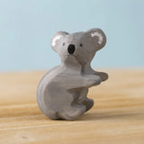 Bumbu Toys handmade wooden Koala figure placed on a wooden surface. 