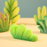 Bumbu Toys lake bush wooden toy scenery piece placed on a wooden surface. 