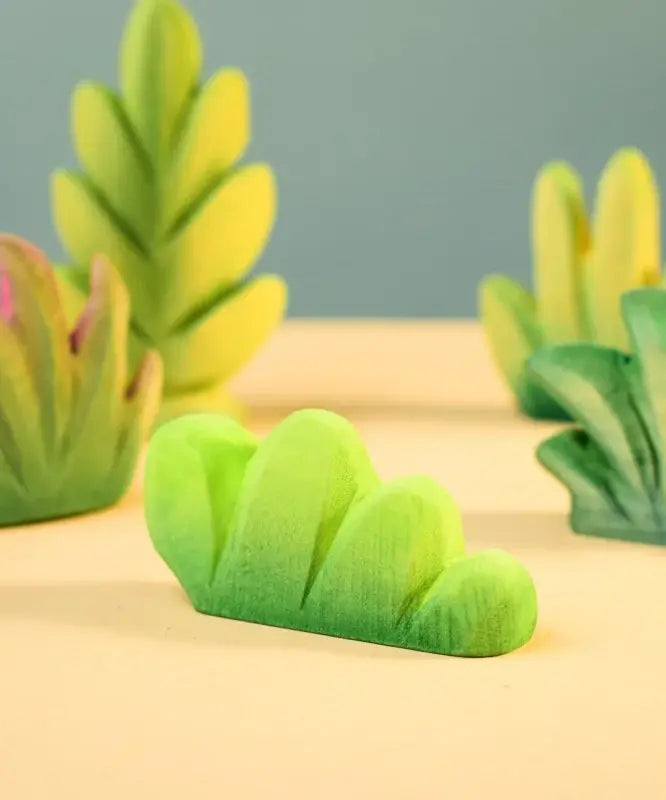 Bumbu Toys lake bush wooden toy scenery piece placed on a wooden surface. 