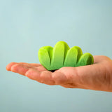 Bumbu Toys lake bush wooden toy scenery piece in an adult's hand.