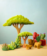 Bumbu Toys lake bush wooden toy scenery piece placed in a small world play scene with lions, rocks, cacti and other bushes and trees.