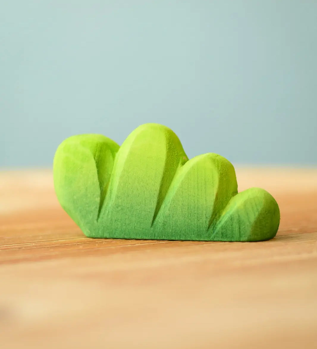 Bumbu Toys lake bush wooden toy scenery piece placed on a wooden surface. 