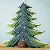 A large Bumbu Snowy Fir Tree placed on a wooden surface. 