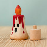 Bumbu handcrafted wooden magic red candle next to a celebration ring peg