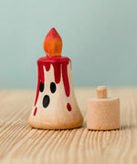 Bumbu handcrafted wooden magic red candle next to a celebration ring peg