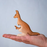 Bumbu Toys Mama Kangaroo & Joey figures set up shown in an adult's hand to show scale.