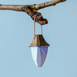 A Bumbu wooden lantern on a twig pictured against a blue background